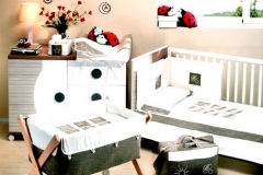 DORMITORIO INFANTIL CON CUNA , CUCO Y CÓMODA CAMBIADOR DE CAJONES Y PUERTA. DIFERENTES TEXTILES PARA VESTIR LOS MUEBLES DE PUERICULTURA.